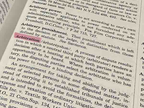 A dictionary, flipped open to the word Arbitration